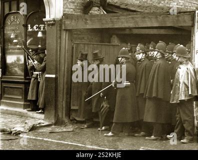 Archivfoto die Belagerung der Sidney Street London 1911: Der Innenminister während des Kampfes: Herr Winston Churchill am Schauplatz der außergewöhnlichen „Schlacht“ in der Sidney Street, abseits der Mile End Road, mit starker Präsenz von Militär und Polizei. Stockfoto