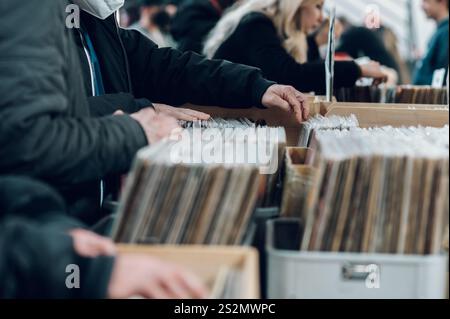 Männerhände suchen die Platten in einem Vinylladen. Kunden suchen nach Schallplatten. Schallplatten im Angebot. Stockfoto