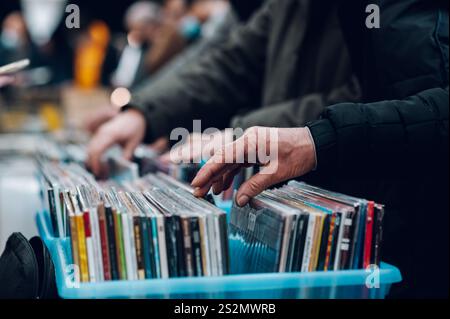 Nahaufnahme von man Hands, die in einem Plattenladen Vinyl-Album durchsuchen. Die Leute besuchen den Vinyl Second Hand Markt. Vinyl-Album im Angebot. Stockfoto