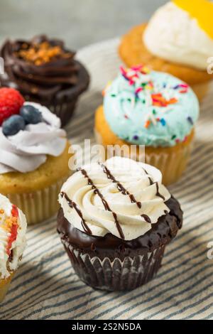 Süße hausgemachte, ausgewählte Gourmet-Cupcakes mit Buttercreme-Zuckerguss Stockfoto