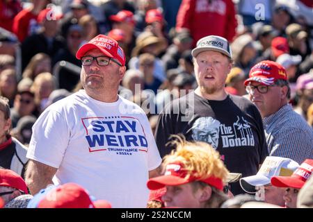 Ein Trump-Unterstützer trägt ein „Stay seltsam“-Hemd bei einer überfüllten Outdoor-Kundgebung während des Präsidentschaftswahlkampfs 2024 Stockfoto