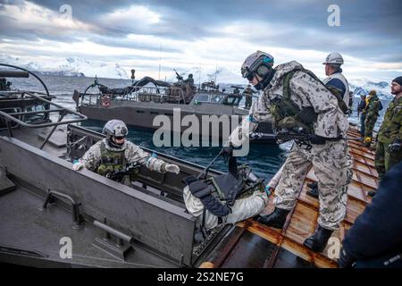 Die finnischen Marines laden während des Standfast Defender 2024 vom Hecktor der USS Gunston Hall aus in ein schwedisches Schnellangriffsboot der CB90-Klasse. Stockfoto