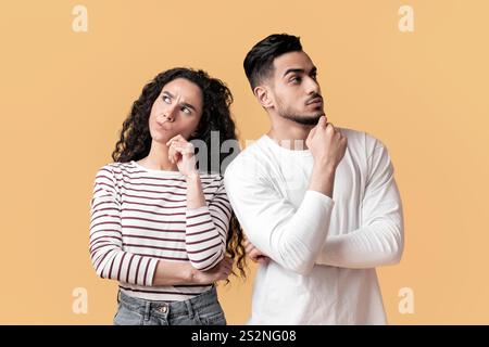 Nachdenklicher Arabischer Junger Mann Und Frau, Die Über Dem Hintergrund Des Gelben Studios Stehen Stockfoto