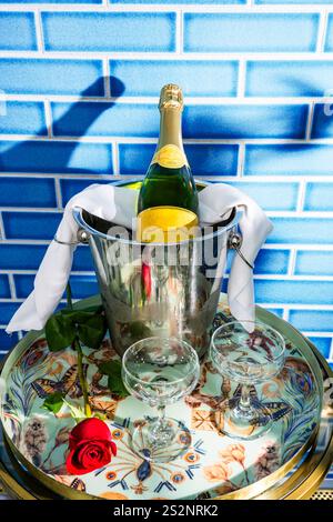 Flasche Champagner im Eimer auf Tablett mit zwei Gläsern Stockfoto