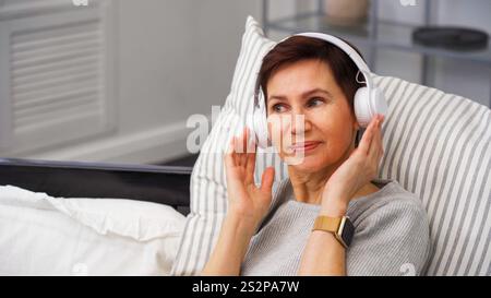 Frau lächelt beim Hörbuch Stockfoto