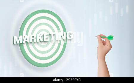 Hand hält einen Pfeil, der auf ein Ziel mit der Bezeichnung Marketing zielt. Symbolisiert Präzision, Strategie und konzeptionellen Ansatz zur Erreichung von Geschäftszielen eff Stockfoto