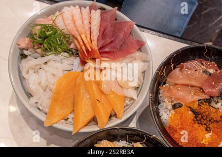 Eine detaillierte Nahaufnahme von drei verschiedenen Schüsseln gefüllt mit verschiedenen Arten von Lebensmitteln, die ordentlich auf einer Tischoberfläche angeordnet sind Stockfoto