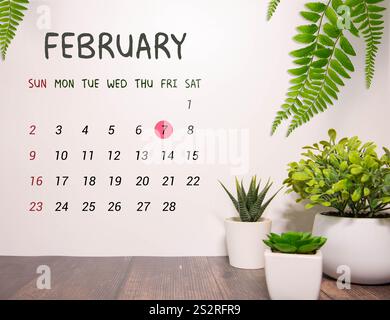 Februar. Tag 7 des Monats Februar, Kalender auf blauem Hintergrund am Arbeitsplatz. Stockfoto