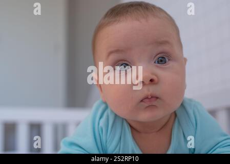 Das Baby liegt auf seinem Bauch und wacht auf Stockfoto