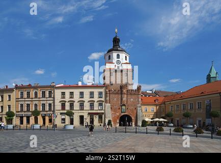 Marktplatz mit historischem Stadttor und umliegenden Gebäuden unter blauem Himmel, Krakauer Tor, Brama Krakowska, Lokietka Platz, Lublin, Polen, Euro Stockfoto