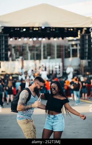 Wunderschönes Paar, das Cocktails trinkt und Spaß beim Musikfestival hat Stockfoto