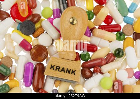 Stempel auf bunten Tabletten, symbolisches Foto für Krankheit, Krankenschild und Medikamente Osterreich Stockfoto