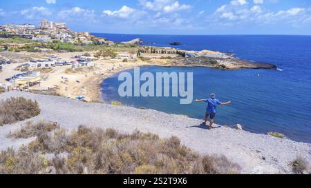 Aerial view of a tourist admiring the beautiful cala reona beach in la manga del mar menor, a popular summer destination in alicante, spain Stockfoto