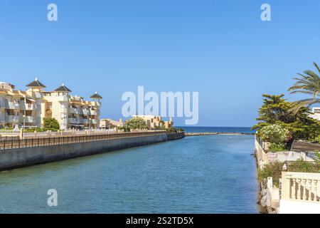 Ruhiges Kanalwasser, das an einem sonnigen Sommertag in der Manga del mar menor in murcia, spanien, ins mittelmeer fließt Stockfoto