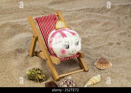 Liegestuhl mit Euro-Währung am Sandstrand. Symbolfoto für Reise-, Urlaubs- und Urlaubskosten. Sparen im Urlaub Österreich Stockfoto