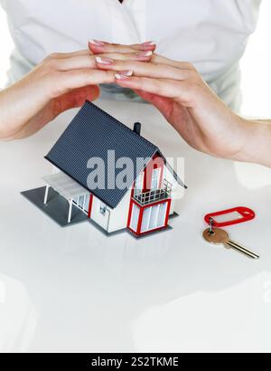 Eine Frau beschützt Ihr Haus und Ihr Zuhause. Gute Versicherungen und seriöse Finanzierungen sorgen für ein beruhigendes Gefühl. Österreich Stockfoto