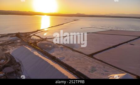 Atemberaubender Blick aus der Luft auf die Salzverdunstungsteiche und die Verarbeitungsanlage im rosa See torrevieja bei Sonnenuntergang, wodurch eine wunderschöne Landschaft entsteht Stockfoto