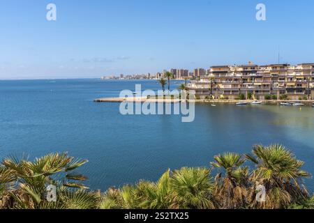 Faszinierende Stadtlandschaft von La Manga im Sommer, mit einem ruhigen blauen Meer, wogenden Palmen und einem malerischen Blick auf die Küste, Cala del Pino Stockfoto