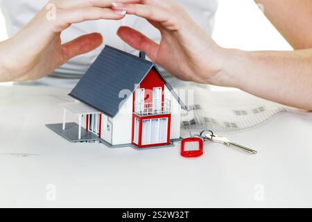 Eine Frau beschützt Ihr Haus und Ihr Zuhause. Gute Versicherungen und seriöse Finanzierungen sorgen für ein beruhigendes Gefühl. Österreich Stockfoto