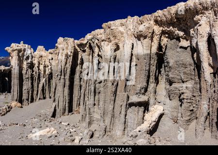 Eine felsige Klippe mit einem blauen Himmel im Hintergrund. Die Klippe besteht aus Felsen und hat eine raue Textur Stockfoto