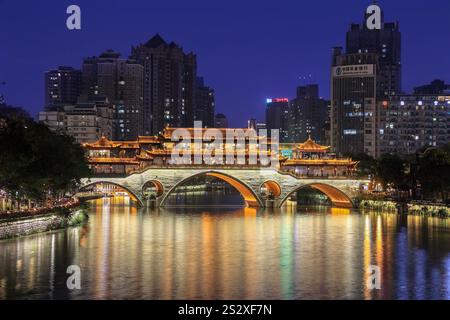 Chengdu, China - 13. Oktober. 2023: Berühmtes Wahrzeichen von Chengdu - Anshun Brücke über den Fluss Jin bei Nacht beleuchtet mit modernen Wolkenkratzern und Landwirtschaft Stockfoto