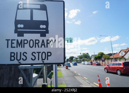 Schild für temporäre Bushaltestelle an der Straße. Autos, die auf der Straße unterwegs sind. Bauarbeiten in Auckland. Stockfoto