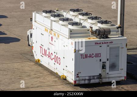 BANGKOK, THAILAND, NOV 30 2024, transportiert Ein Traktor eine Aircraft Air Conditioning Unit (ACU) auf der Piste Stockfoto