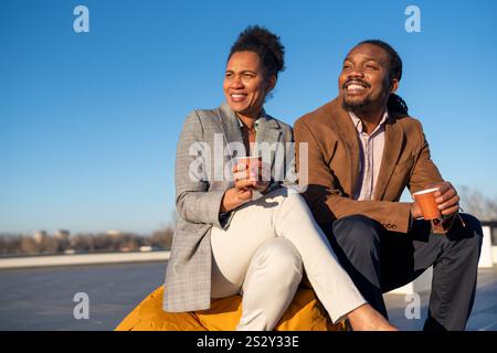 Glückliche Geschäftskollegen genießen die Kaffeepause und haben Spaß beim Gespräch auf dem Balkon Stockfoto