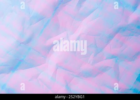 Ein abstrakter Hintergrund mit pastellfarbenen Rosa- und Blautönen mit strukturiertem, zerknittertem Papiereffekt. Stockfoto