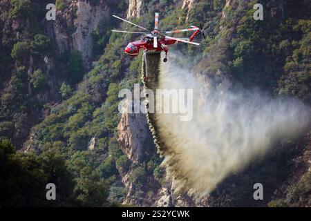 LOS ANGELES COUNTY, KALIFORNIEN, USA – Dezember 2024 – Ein spezialisierter Löschhubschrauber lässt Wasser auf einen Canyon im Los Angeles County, Kalifornien, fallen. Stockfoto