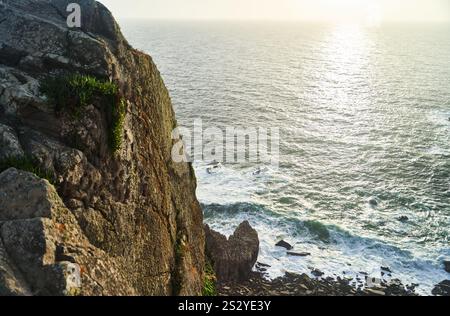 Erleben Sie den atemberaubenden Blick auf die Küste bei Sonnenuntergang mit wunderschönen Rocky Cliffs und dem Meer Stockfoto