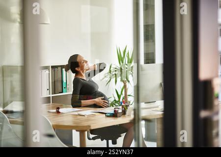 Schwangere, professionelle Frau und Nackenschmerzen in der Praxis mit Muskelverletzung, Beschwerden und schlechter Körperhaltung. Schwangerschaft, Angestellter und medizinischer Burnout am Schreibtisch Stockfoto