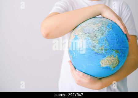 Person mit einer Plastikerdkugel Stockfoto