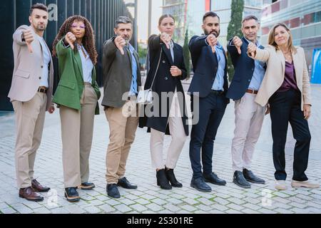 Selbstbewusstes Business-Team, das in urbaner Umgebung nach vorne zeigt Stockfoto