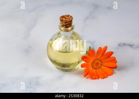 Pflanzliche Calendula officinalis im Glas und Tropfenöl. Calendula-Öl. Stockfoto