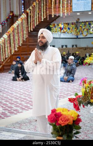 Ein Priester in weiß betet und meditiert im Baba Makhan Shah Lubana Sikh Center in South Richmond Hills Queens, New York Stockfoto