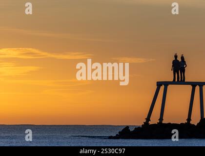 Newbiggin-by-the-Sea, Großbritannien, das „Paar“, das der Bildhauer Sean Henry bei Sonnenaufgang geschaffen hat Stockfoto