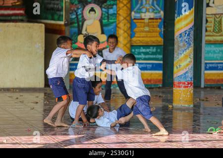 Provinz Kandal, Kambodscha. Januar 2025: Schüler haben Spaß beim Kämpfen in der Pagode auf dem Schulhof. Zurück zur Schule für Khmer-Kinder in Phnom Penh Vororten, später als in anderen südostasiatischen Ländern. Gestern war ein Feiertag, als Kambodschaner am 7. Januar 1979 den Sieg über den Völkermord feierten, mit der Befreiung der Hauptstadt und dem Fall des Pol Pot-Regimes. Obwohl das Land überwiegend buddhistisch ist (93 % bis 97 %), umfassen die „Winterschulferien“ Weihnachten, den kambodschanischen Friedenstag am 29. Dezember, das Internationale Neujahr und den Siegestag. Quelle: Kevin Izorce/Alamy Live News Stockfoto