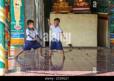 Provinz Kandal, Kambodscha. Januar 2025: Schüler haben Spaß beim Kämpfen in der Pagode auf dem Schulhof. Zurück zur Schule für Khmer-Kinder in Phnom Penh Vororten, später als in anderen südostasiatischen Ländern. Gestern war ein Feiertag, als Kambodschaner am 7. Januar 1979 den Sieg über den Völkermord feierten, mit der Befreiung der Hauptstadt und dem Fall des Pol Pot-Regimes. Obwohl das Land überwiegend buddhistisch ist (93 % bis 97 %), umfassen die „Winterschulferien“ Weihnachten, den kambodschanischen Friedenstag am 29. Dezember, das Internationale Neujahr und den Siegestag. Quelle: Kevin Izorce/Alamy Live News Stockfoto