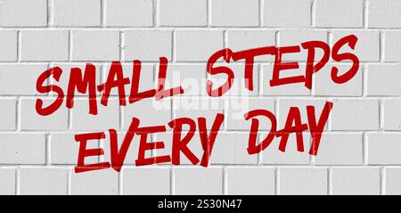Graffiti an einer Ziegelmauer - jeden Tag kleine Stufen Stockfoto