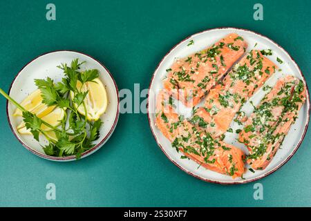 Frischer roher Lachsfilet in grüner Knoblauchmarinade, fertig zum Rösten. Gravlax. Stockfoto