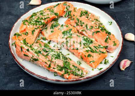 Frischer roher Lachsfilet in grüner Knoblauchmarinade zum Backen bereit. Gravlax. Stockfoto