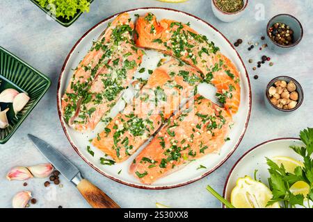 Roher, ungekochter Lachs oder Forellenfilet in grüner Knoblauchmarinade. Flache Lagen Stockfoto