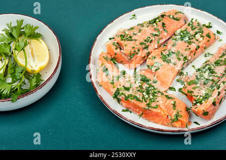 Frischer roher Lachsfilet in grüner Knoblauchmarinade, fertig zum Rösten. Stockfoto