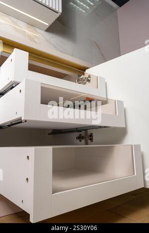 Ein moderner, leerer Küchenschrank mit elegantem weißem Design und transparenten Ablageflächen. Ideal für die Präsentation von Organisation und zeitgenössischem Zuhause Stockfoto