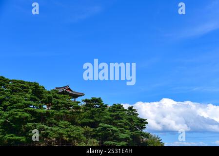 Ein kleines Gebäude liegt auf einem Hügel. Der Himmel ist blau und Wolken am Himmel Stockfoto