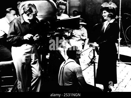 DER PFLUG UND DIE STARS DER REGISSEUR JOHN FORD AM SET MIT STAR BARBARA STANWYCK. KAMERAMANN JOSEPH AUGUST IST DIREKT UNTER DER KAMERA UND SCHAUT NACH OBEN. Datum: 1937 Stockfoto