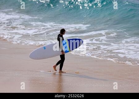 Surfer mit Surfbrett, Playa Piedra Surfstrand, El Cotillo, Fuerteventura, Kanarische Inseln, Spanien. Stockfoto