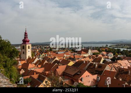 Ein Blick aus der Vogelperspektive auf eine malerische kleine Stadt mit einer prominenten Kirche und einem wunderschönen See im Hintergrund Stockfoto