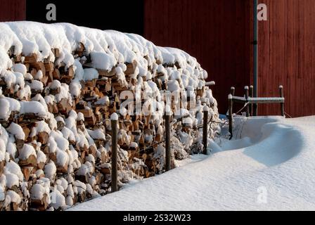 Schnee auf Baumstämmen für einen Kamin Stockfoto